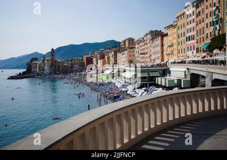 Camogli, Ligurien, Italien - Juni, 2022: Strand mit Sonnenschirmen und Strandpromenade mit typisch italienischen Häusern. Ferienort an der italienischen Riviera am Mittelmeer Stockfoto
