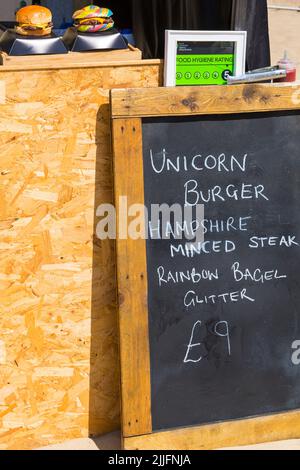 Unicorn Burger Hampshire Hacksteak Regenbogen Bagel Glitzer zum Verkauf £9 auf Food Stand bei der Veranstaltung in Poole, Dorset UK im Juli Stockfoto