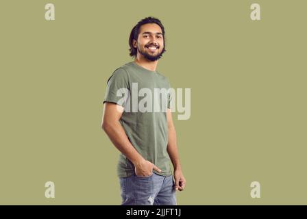 Porträt eines gutaussehenden selbstbewussten indischen Kerl trägt Freizeitkleidung auf khaki Hintergrund. Stockfoto
