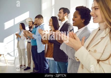 Ein freudiges und zufriedenes Publikum applaudiert den Referenten während einer Geschäftskonferenz oder eines Seminars. Stockfoto