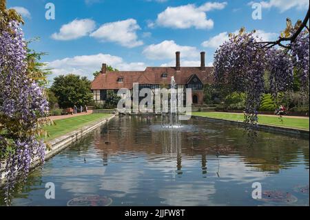 Der Kanal und das Labor mit Glyzinien im Vordergrund im RHS Wisley Garden Surrey Stockfoto