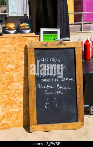 Unicorn Burger Hampshire Hacksteak Regenbogen Bagel Glitzer zum Verkauf £9 auf Food Stand bei der Veranstaltung in Poole, Dorset UK im Juli Stockfoto