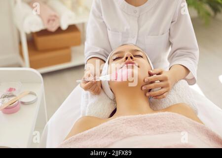 Frau genießt Tonmaske während der Gesichtsbehandlung im Spa-Salon oder Schönheitssalon Stockfoto