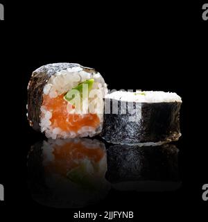 Klassische Sushi-Rolle mit Lachs auf schwarzem Hintergrund für die Speisekarte. asiatische Küche Stockfoto