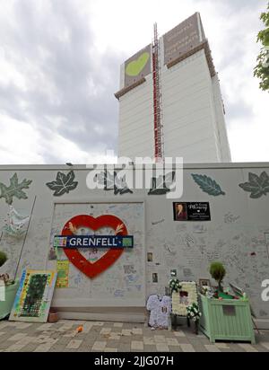 Grenfell Tower Feuertragödie Block, hinter der Gedenkmauer für die 72 Opfer gezeigt. Grenfell United, für immer, nach dem Beschuss der Verkleidung im Jahr 2017 Stockfoto