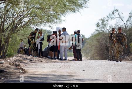 Houston, Texas, USA. 24.. Juli 2022. Soldaten der texanischen Nationalgarde stehen am 24. Juli 2022 neben Migranten in Eagle Pass, Texas, USA. Quelle: Nick Wagner/ Xinhua/Alamy Live News Stockfoto