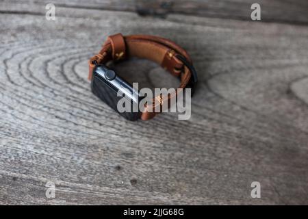 Handgefertigtes braunes Leder Vintage Uhrenarmband Handwerkskunst auf Holzhintergrund Stockfoto