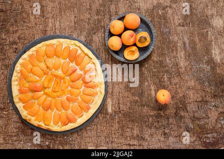 Obstpizza mit Pfirsichen auf einem dunklen Holztisch, hausgemachter vegetarischer Sommerkuchen, Draufsicht Stockfoto