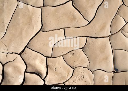 Abstraktes Muster von trockenem rissenen Lehmschlamm im ausgetrockneten Flussbett, verursacht durch längere Trockenheit. Swakop-Fluss, Namibia, Afrika Stockfoto