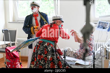 Potsdam, Deutschland. 26.. Juli 2022. Clowns Beta (l) und Widu besuchen Senioren in der Ernst von Bergmann Klinik. Die Clownsbesuche wurden speziell für körperlich oder geistig beeinträchtigte Patienten entwickelt und tragen zur Verbesserung ihrer Lebensqualität bei. Quelle: Jens Kalaene/dpa/Alamy Live News Stockfoto