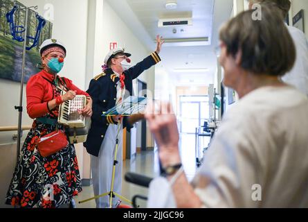 Potsdam, Deutschland. 26.. Juli 2022. Clowns Beta (l) und Widu besuchen Senioren in der Ernst von Bergmann Klinik. Die Clownsbesuche wurden speziell für körperlich oder geistig beeinträchtigte Patienten entwickelt und tragen zur Verbesserung ihrer Lebensqualität bei. Quelle: Jens Kalaene/dpa/Alamy Live News Stockfoto