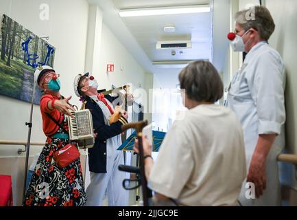 Potsdam, Deutschland. 26.. Juli 2022. Clowns Beta (l) und Widu besuchen Senioren in der Ernst von Bergmann Klinik. Die Clownsbesuche wurden speziell für körperlich oder geistig beeinträchtigte Patienten entwickelt und tragen zur Verbesserung ihrer Lebensqualität bei. Quelle: Jens Kalaene/dpa/Alamy Live News Stockfoto