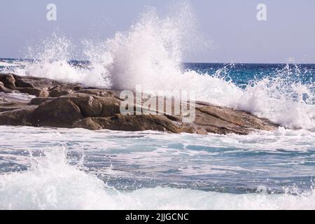 Wasser, das an stürmischen Tagen am Strand von Seccheto, Elba, gegen Felsen spritzt Stockfoto