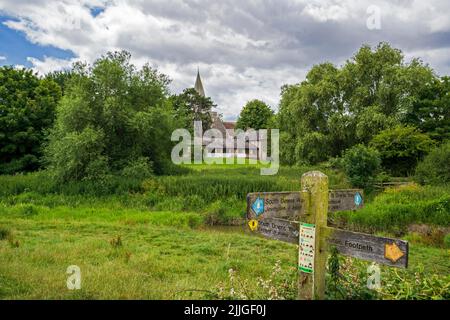 South Downs Way-Schilder neben dem Cuckmere River und der St. Andrew's Church in Alfriston, East Sussex. Stockfoto