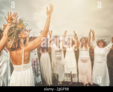 Frauen im Blumenkranz auf sonniger Wiese, Blumenkrone, Symbol der Sommersonnenwende. Stockfoto
