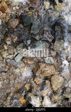 Der Gebirgsfluss fließt schnell aus der Nähe über Felsen. Stockfoto