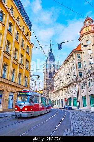 Die malerische rote Vintage-Straßenbahn fährt vor dem mittelalterlichen Henry's Tower, Prag, Tschechische Republik Stockfoto