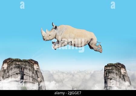 Konzept der schweren Nashorn springen zwischen Bergen Felsen Stockfoto