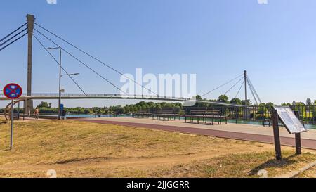 Sremska Mitrovica, Serbien - 22. Juli 2022: Fußgängerbrücke des Heiligen Irenäus über den Fluss Sava. Stockfoto