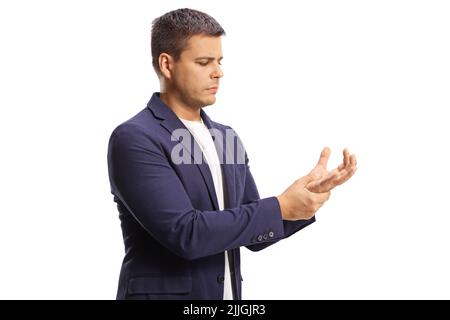 Junger Mann, der an Arthritis leidet und sein schmerzhaftes Handgelenk isoliert auf weißem Hintergrund hält Stockfoto