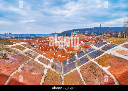 Die roten Dächer und Kuppeln von Prag vor dem Petrin-Hügel, vom Aussichtspunkt am Schwarzen Turm mit roten Ziegelsteinmauern aus gesehen, Tschechische Republik Stockfoto