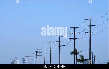 Reihe von Strommasten gegen einen blauen Himmel während einer Reise Stockfoto