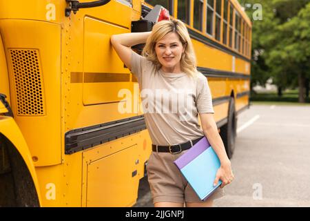 Porträt einer Lehrerin in der Nähe des Schulbusses Stockfoto