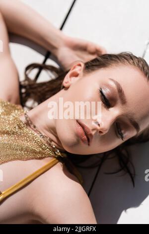 Draufsicht auf hübsche Frau mit Make-up auf weißer Holzoberfläche Stockfoto