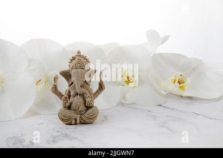 Happy Ganesh Chaturthai Festival, Lord Ganesha Statue mit schönen Orchideenblumen auf weißem Hintergrund, Stockfoto