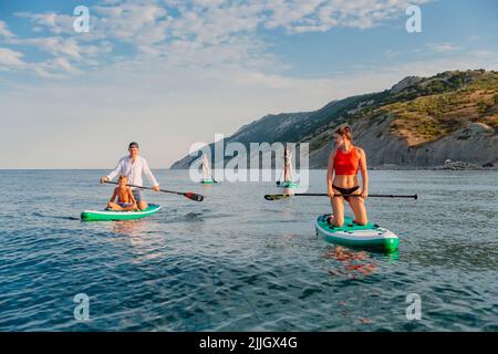 11. Juli 2022. Dalaman, Türkei. Kleine Gruppe aktiver Menschen auf Stand Up Paddle Board auf ruhiger See. Wassersport auf Red Paddle SUP Board im Ozean. Stockfoto