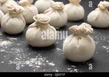 Rohe Knödel aus der Nähe. Doug auf dem Tisch. Schwarzer Hintergrund. Stockfoto