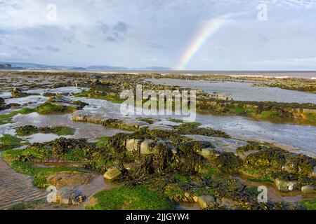 Ein Regenbogen über dem Bristol Channel vom East Quantoxhead Beach an der Küste von Somerset, England. Stockfoto