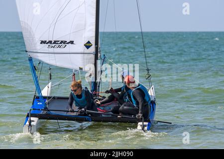 Drei Frauen segeln mit einem ausnehmbaren Katamaran auf See Stockfoto