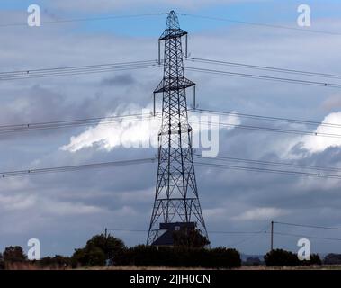 Nahaufnahme eines großen Hochspannungsmasten, der die im Atomkraftwerk Dungeness erzeugte Energie transportiert, Stockfoto