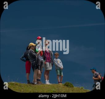 Junge Familie auf einem Hügel in Velika Planina mit dunkelblauem Himmel Stockfoto