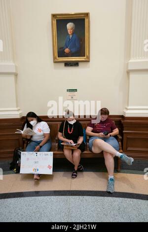 Austin Texas USA, Juli 26 2022: Aktivisten, die gegen Buchzensur in öffentlichen Schulklassen und Bibliotheken protestieren, sitzen in der Rotunde des Capitol und lesen einige der 850 Bücher, die auf der Liste der "unbequemen" Titel eines republikanischen Gesetzmachers aufgeführt sind. Die Frauen sitzen unter einem Porträt der ehemaligen Gov. Ann Richards. Kredit: Bob Daemmrich/Alamy Live Nachrichten Stockfoto