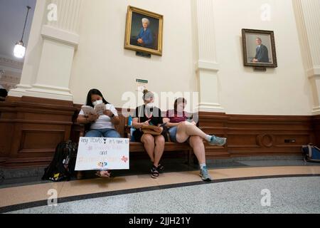 Austin Texas USA, Juli 26 2022: Aktivisten, die gegen Buchzensur in öffentlichen Schulklassen und Bibliotheken protestieren, sitzen in der Rotunde des Capitol und lesen einige der 850 Bücher, die auf der Liste der "unbequemen" Titel eines republikanischen Gesetzmachers aufgeführt sind. Die Frauen sitzen unter einem Porträt der ehemaligen Gov. Ann Richards. Kredit: Bob Daemmrich/Alamy Live Nachrichten Stockfoto