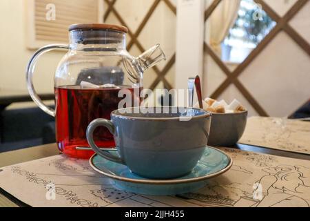 Tee Zeit. tasse, Zucker und Glas Teekannen mit Tee Stockfoto