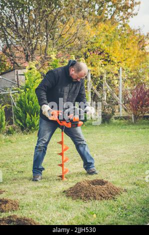 Mann bereitet Löcher für die Pflanzung von Trauben in neuen Weinberg Stockfoto