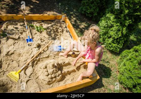 Adorable blonde Mädchen mit Spaß mit Sand auf dem Spielplatz Stockfoto