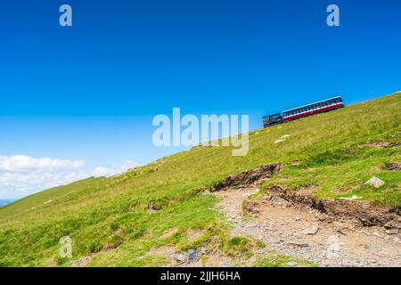 SNOWDON, WALES - 09. JULI 2022: Bergbahn bringt Touristen vom Gipfel des Mount Snowden zurück in die Stadt Llanberis Stockfoto