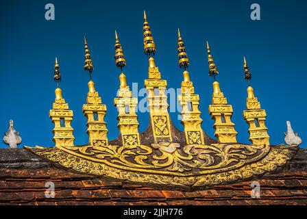 Ein sogenannter 'Dok so Fa' in Luang Prabang, goldene Dachornamente, die sich in der Mitte des Dachbalkens befinden und das buddhistische Universum repräsentieren Stockfoto