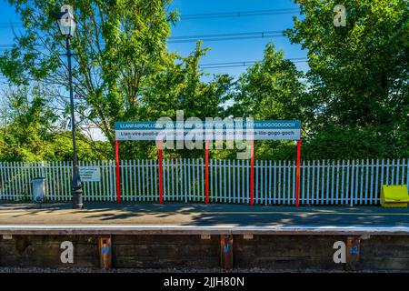 Llanfair­pwllgwyngyll­gogery­chwyrn­drobwll­llan­tysilio­gogo­goch, Anglesey - 10. JULI 2022: Zeichen mit 58 Zeichen Name der Stadt auf dem Bahnhof Stockfoto