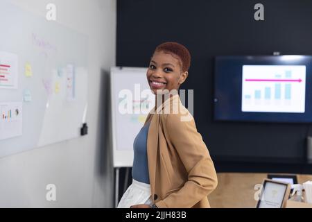 Porträt einer lächelnden afroamerikanischen jungen Geschäftsfrau im Vorstandszimmer Stockfoto