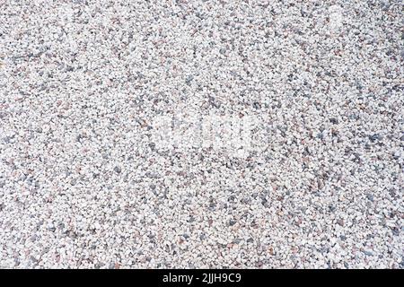 Gemischte kleine graue gebrochene Felsen, lockerer Kies, Straßenbau. Kalksteinaggregat. Hintergrund aus zerkleinertem Stein Stockfoto