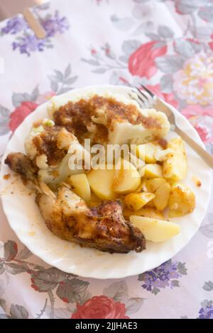 Gebratene Hähnchenschenkel mit Blumenkohl und Kartoffeln Stockfoto