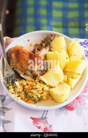 Gebratenes Hähnchenschenkel mit Kartoffeln und Salat Stockfoto