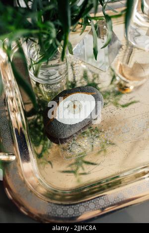 Gemalter Fels aus dem bösen Auge auf silbernem Tablett, Nachttisch Stockfoto