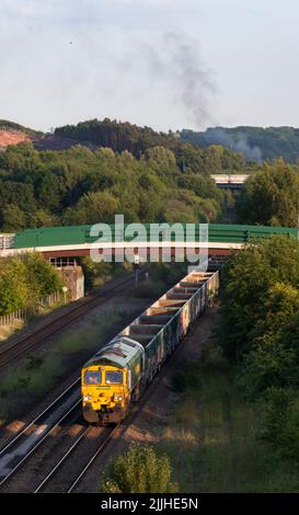 Die Freightliner-Diesellokomotive der Baureihe 66 fährt mit einem Güterzug leerer Zuschlagstoffwagen an Bennerley im Erewash Valley, Nottinghamshire, Großbritannien vorbei Stockfoto