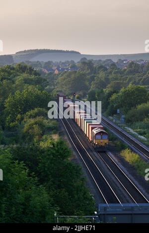 DB Cargo Rail UK Diesellokomotive der Baureihe 66, die Bennerley im Erewash Valley, Nottinghamshire, Großbritannien, mit einem Güterzug mit Containern passiert Stockfoto